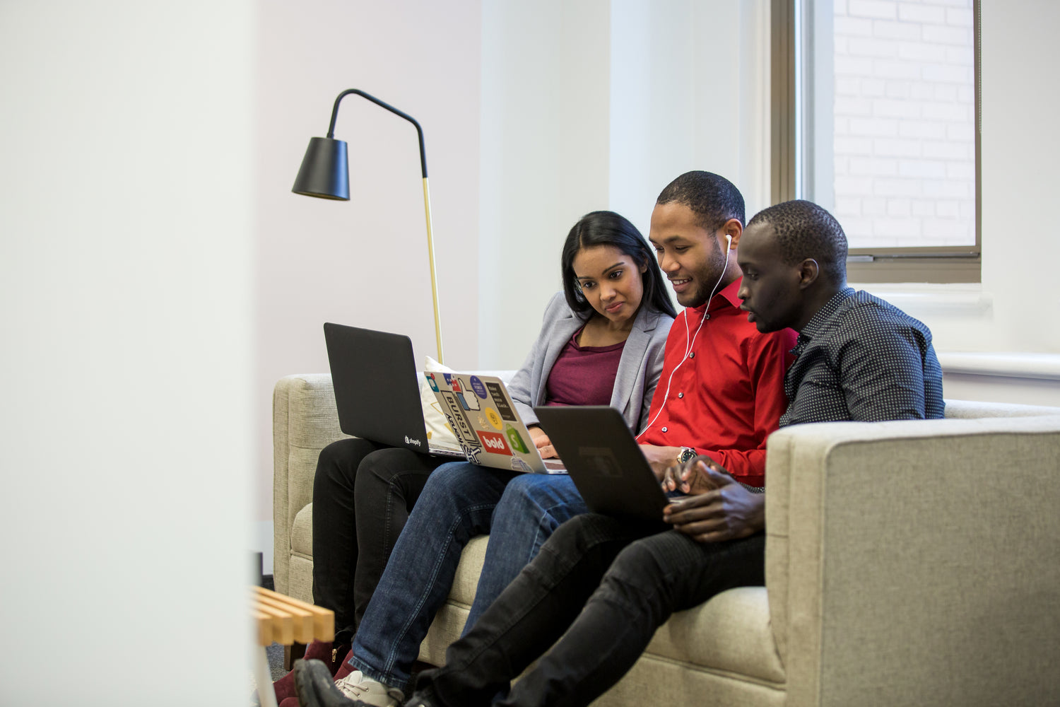 three-friends-working-on-couch